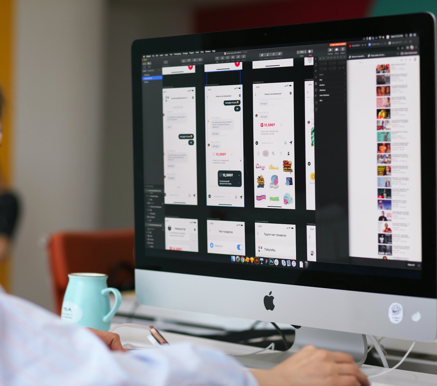 Persona diseñando wireframes de aplicaciones en una computadora de escritorio con una taza verde azulado.
